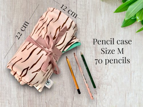 opgerolde roze pennen etui met drie potloden ervoor