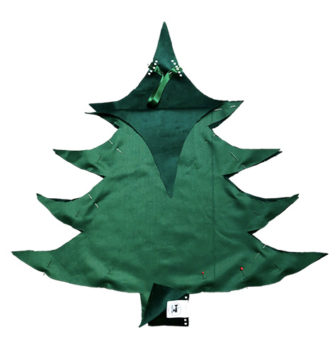 plaatsing van het label en het lusje op de groene stof voor het patroon van de kerstboom